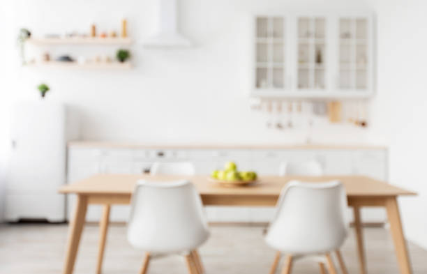 istock Blurred background of light kitchen interior in scandinavian style with wooden dining table, copy space 1322963846