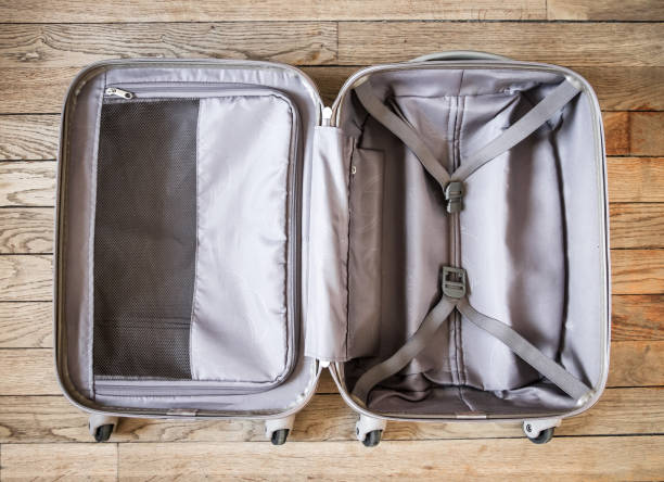 istock Open suitcase isolated on old wooden background 1322966207