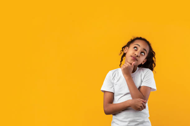 istock Pensive black girl looking up aside at free copy space 1322973208