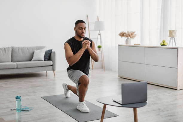 istock African American Guy Doing Forward Lunge Exercise Near Laptop Indoor 1322973545