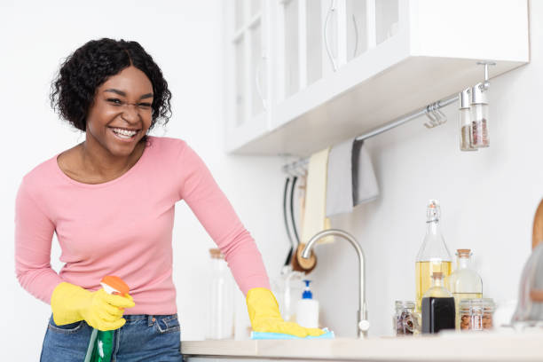 istock Positive black lady cleaning kitchen, erasing sink 1322974363