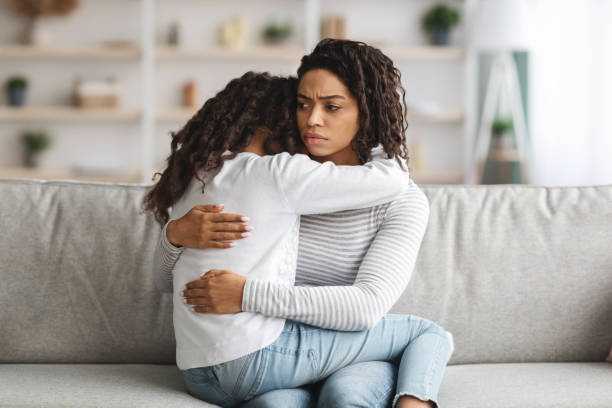 istock Depressed black mother hugging her daughter, closeup 1322974486