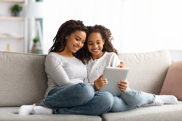 istock Cute african american mother and kid using digital tablet together 1322974557