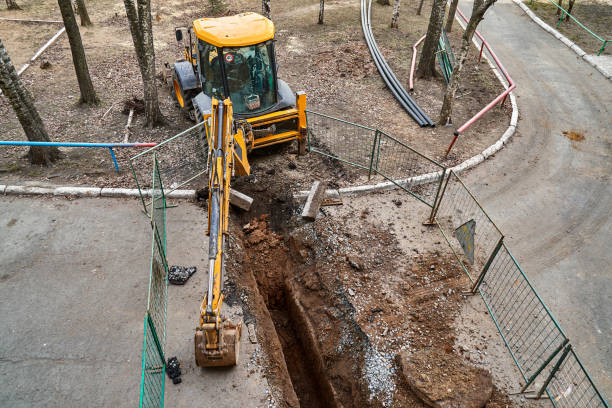 istock Excavator with bucket stands by deep pit change water pipes 1322975361