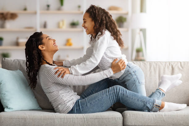 istock Loving black mother and kid bonding while relaxing on couch 1322975378