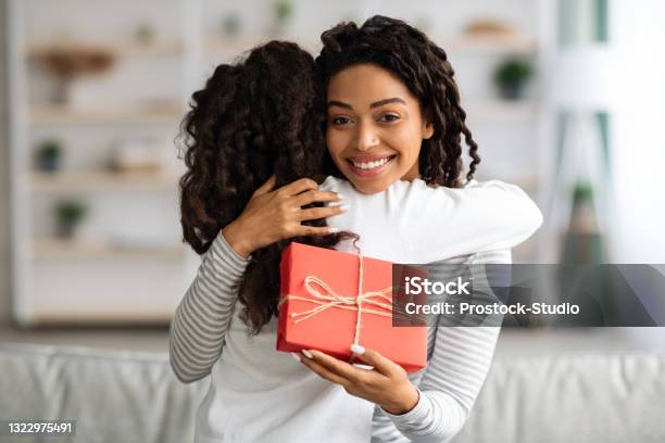 Curly Black Girl Greeting Her Mom With Birthday Stock Photo - Download Image Now - Mother, Birthday Present, Gift