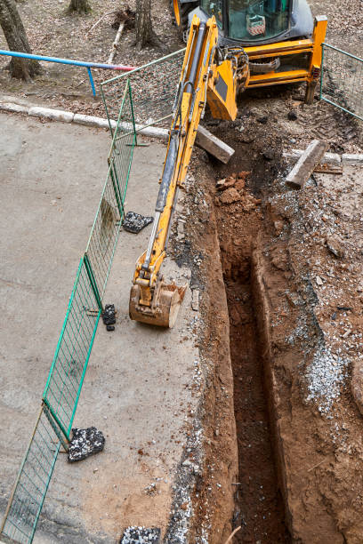 istock Excavator with bucket stands by deep pit change water pipes 1322975813
