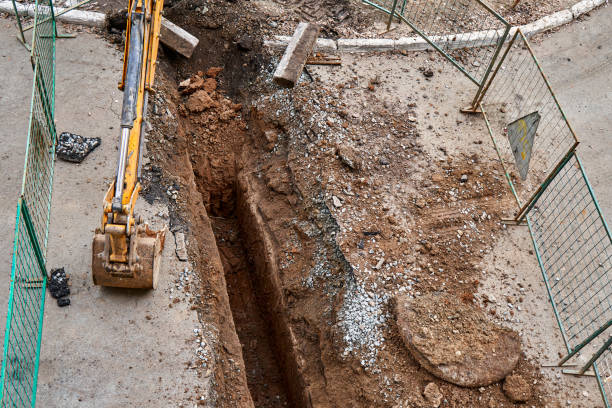 istock Excavator with bucket stands by deep pit change water pipes 1322975844