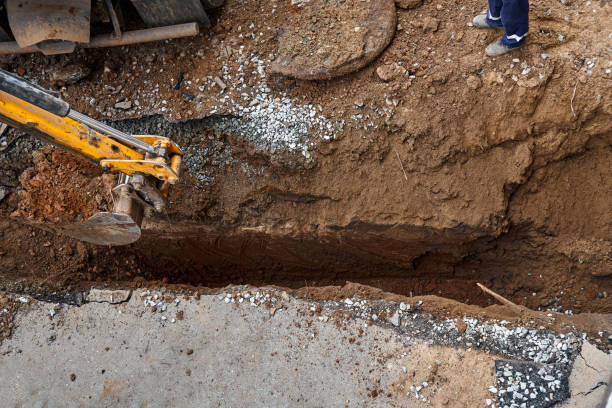 istock Excavator digs deep pit to change and lay new water pipes 1322975873