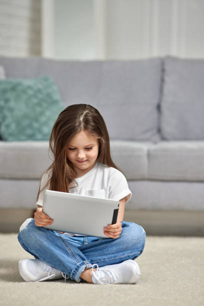 istock Little kid girl looking at tablet at home 1322976586