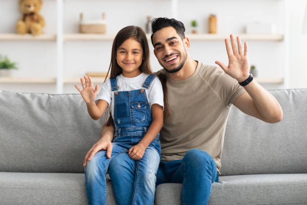 istock Happy family waving hands and posing at camera 1322976678