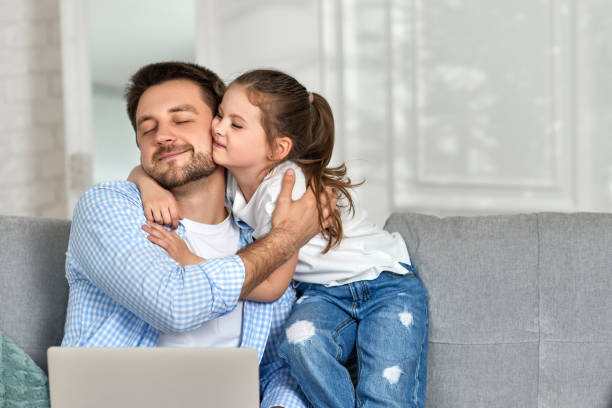 istock happy little girl hugs her father while he working 1322977744