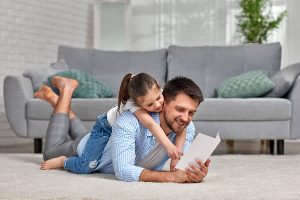 istock daughter congratulates her father and gives him postcard. 1322977892
