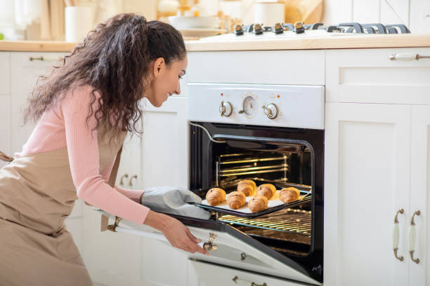 istock Home Cooking. Beautiful Brunette Lady Baking In Kitchen, Taking Tray Out Oven 1322978367