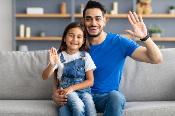 istock Family waving hands and posing at camera 1322978373