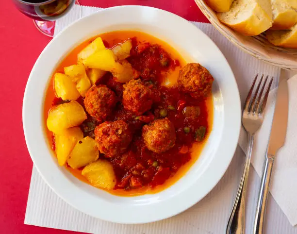 Photo of Spanish meatballs Albondigas in tomato sauce with baked potatoes