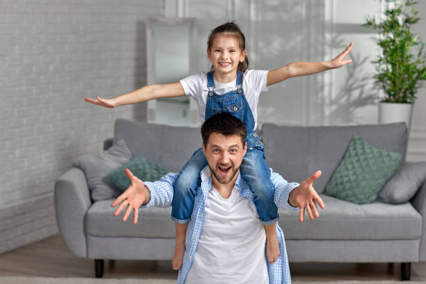 istock happy dad holds her cute child daughter on shoulders 1322979454