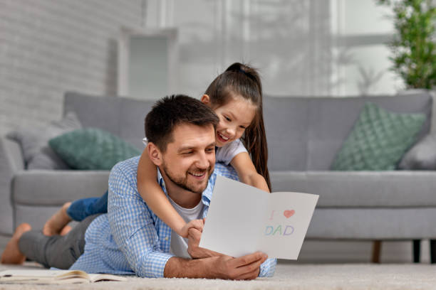 istock Father's day. daughter giving dad a greeting card 1322979665