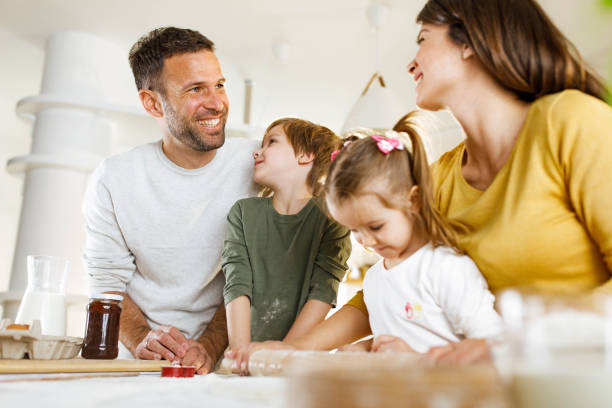 istock Happy family talking while making a cake in the kitchen. 1322981050