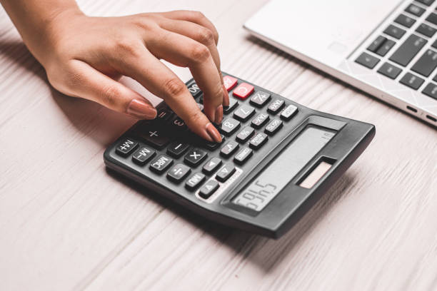 istock Closeup of using calculator on white textured background stock image. 1322982350