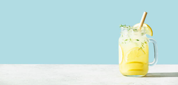 Banner. Lemonade on blue background close up, copy space Banner. Lemonade on blue background close up. Summer drinks and vacation concept. Sunny day shadows, copy space lemon soda photos stock pictures, royalty-free photos & images