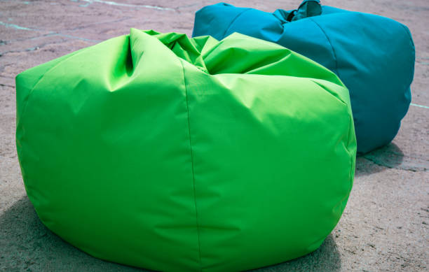 istock Two bag chairs, green and blue, on the open air resting on the stone pavement. Selective focus. Stuf for sea vacation, leisure and tourism. 1322984641