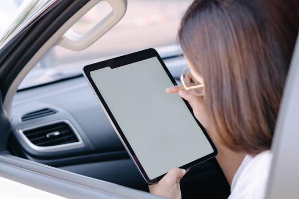 istock Closeup asian woman using digital tablet in a car with happy face 1322986470