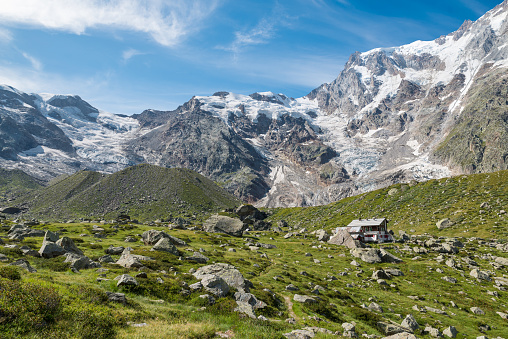 Panorama of the European Alps with the Monte Rosa at the Zamboni Zappa refuge at the Pedriola alp, Macugnaga. Macugnaga village is an important summer and winter resort in northern Italy. Macugnaga (Staffa - Pecetto)  is located in the Anzasca Valley (Val d'Ossola) in the province of Verbano Cusio Ossola, Piedmont. It is at the base of the spectacular east wall of Monte Rosa (4.636 m), the only wall of the Alps with Himalayan features