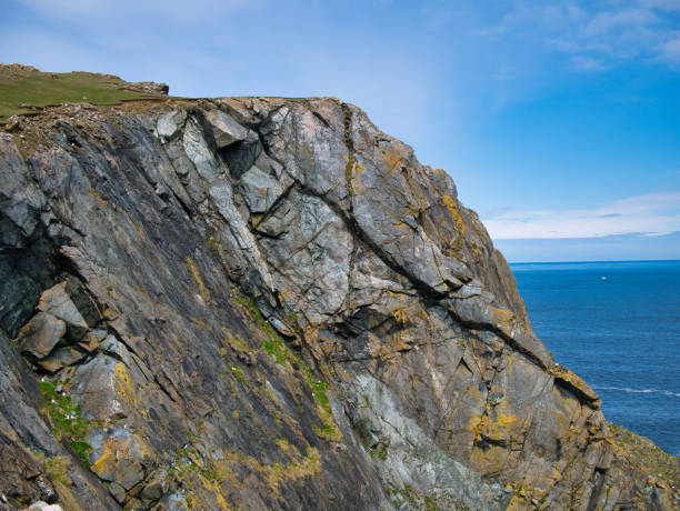 Steeply inclined, fractured strata of the Shetland Ophiolite Complex - Metaharzburgite. Metamorphic Bedrock formed approximately 419 to 1000 million years ago in the Silurian period - Unst, Shetland, UK estratos abruptamente inclinados y fracturados del complejo ofiolita de las shetland - metaharzburgita. el lecho rocoso metamórfico se formó hace aproximadamente 419 a 1000 millones de años en el período silúrico - unst, shetland, reino unido