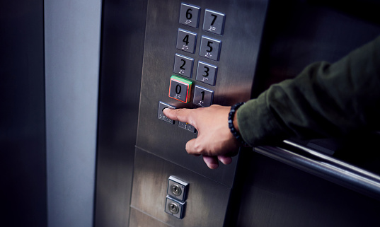 Foto de un hombre irreconocible presionando un botón en un ascensor photo