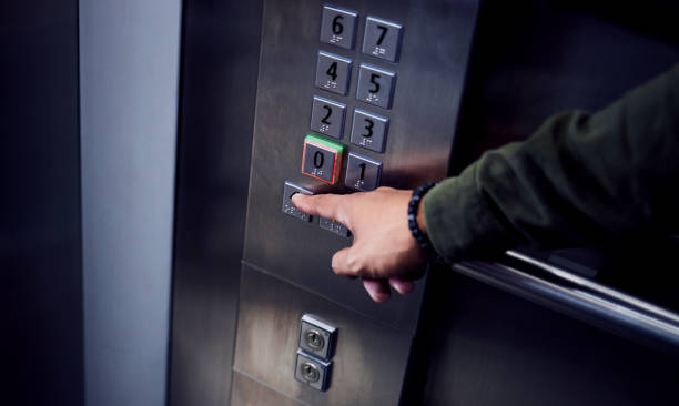 plan d’un homme méconnaissable appuyant sur un bouton dans un ascenseur - elevator photos et images de collection