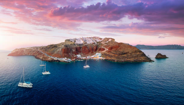 Panoramic aerial view to the villages of Oia and Ammoudi during sunset time Panoramic aerial view to the villages of Oia and Ammoudi surrounded by the steep, volcanic rock formations on Santorini island, Greece, during summer sunset time santorin stock pictures, royalty-free photos & images