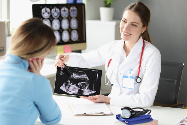 femme obstétricienne gynécologue montrant une photographie patiente de l’examen échographique du fœtus sur tablette numérique - foetus étape de fécondation humaine photos et images de collection