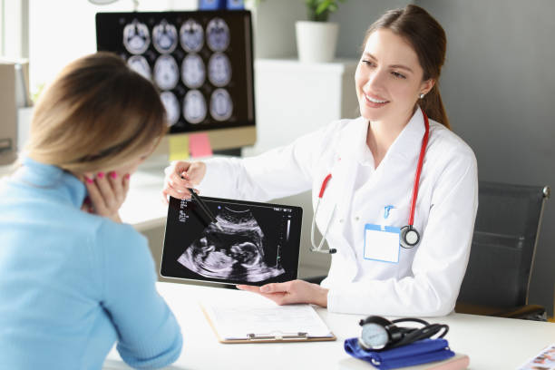 디지털 태블릿에 태아의 초음파 검사의 환자 사진을 보여주는 여성 산부인과 의사 - human pregnancy ultrasound medical exam doctor 뉴스 사진 이미지