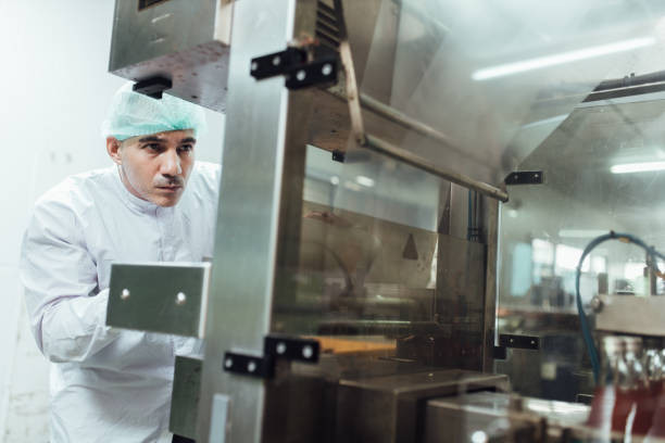 istock workers in factory checking products. workers inspecting production line at drinks production factory. working Concept 1322992588