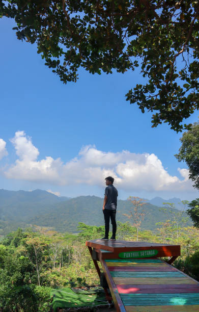 istock Man on a mountain peak with mountains view with a casual shirt 1322993154