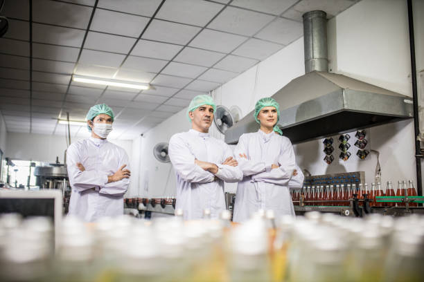 istock Groub workers in production line at drinks production factory background 1322993319
