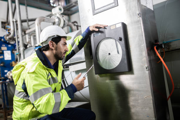 istock Engineer in uniform holding a tablet in her hands and conducting an inspection at the machine in Factory. Industrial production concept 1322993320