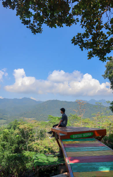 istock Man on a mountain peak with mountains view with a casual shirt 1322993368