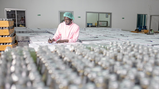 African american worker inspecting production line at drinks production factory. working Concept. workers checking juice bottles before shipment. Inspection quality control.