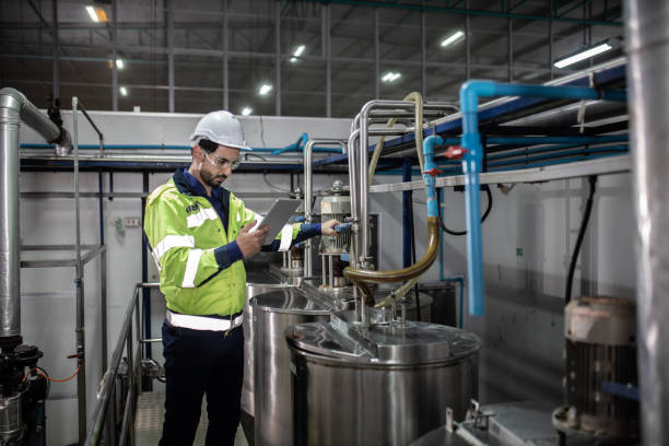 istock Engineer in uniform holding a tablet in her hands and conducting an inspection at the machine in Factory. Industrial production concept 1322993572