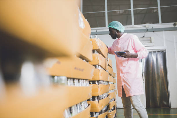 istock African american worker inspecting production line at drinks production factory. working Concept. workers checking juice bottles before shipment. Inspection quality control. 1322993673