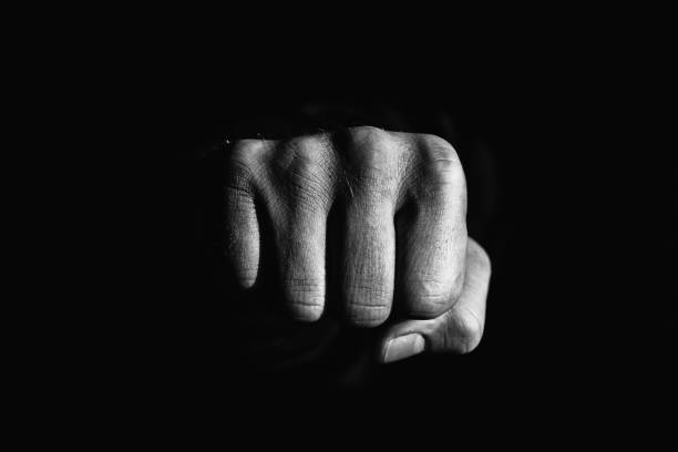 istock fist in the dark. Symbol of strength and aggression. 1322995109