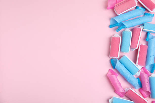 istock Different hair curlers on pink background, flat lay. Space for text 1322996498