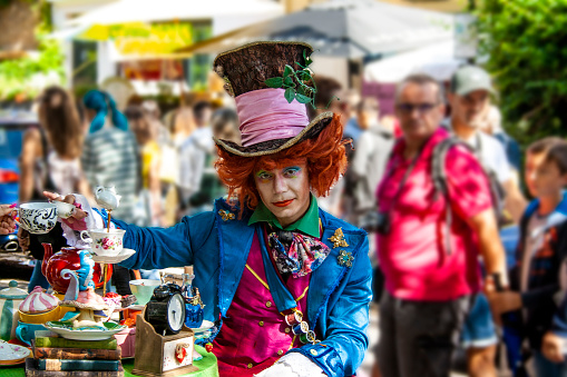 A street artist on the streets of Notting Hill in London, dressed as the Mad Hatter from Lewis Carroll's famous story, \