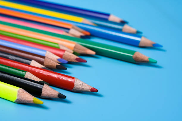 istock Colored pencils on the table. Color pencils on blue background. 1322998946