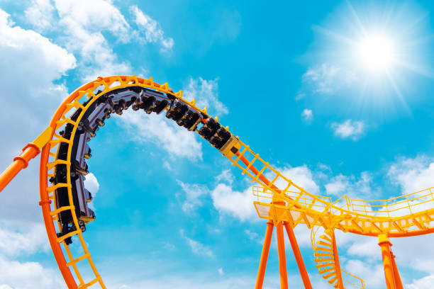roller coaster high in the summer sky at theme park most excited fun and joyful playing machine roller coaster high in the summer sky at theme park most excited fun and joyful playing machine amusement park ride photos stock pictures, royalty-free photos & images