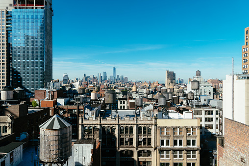 Skyline of Manhattan in New York City with water towers on the rooftops a sunny day with blue sky. Travel to New York