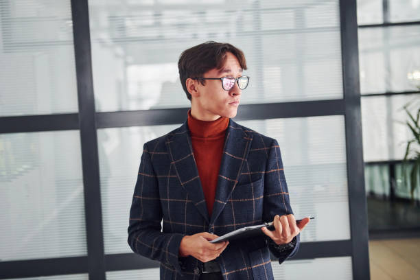 istock Office worker in glasses and in formal clothes standing indoors 1323003025