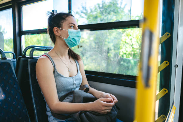 istock Woman in bus wearing face mask 1323003175
